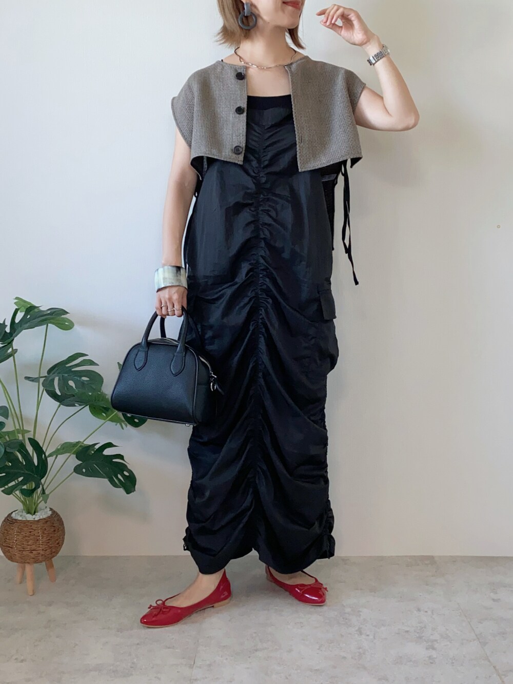 ブラック系のワンピース、ブラック系のボストンバッグ、レッド系のバレエシューズを着用したレディースの夏コーディネートの3枚目の写真