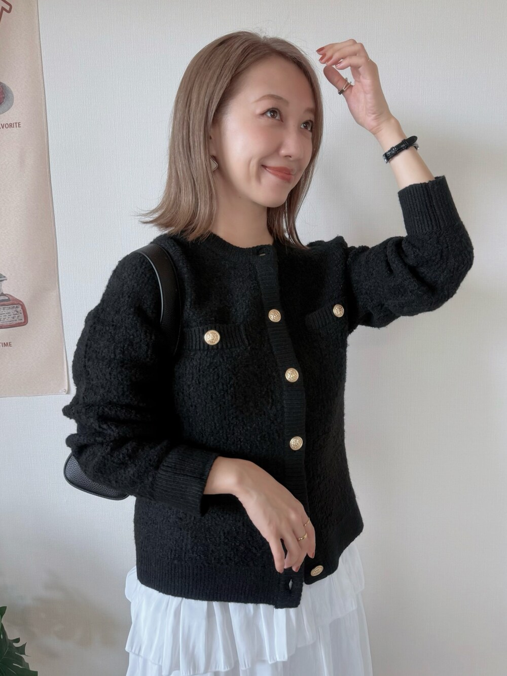 ブラック系のブーツ、ホワイト系のスカート、ブラック系のカーディガン/ボレロを着用したレディースの秋コーディネートの3枚目の写真