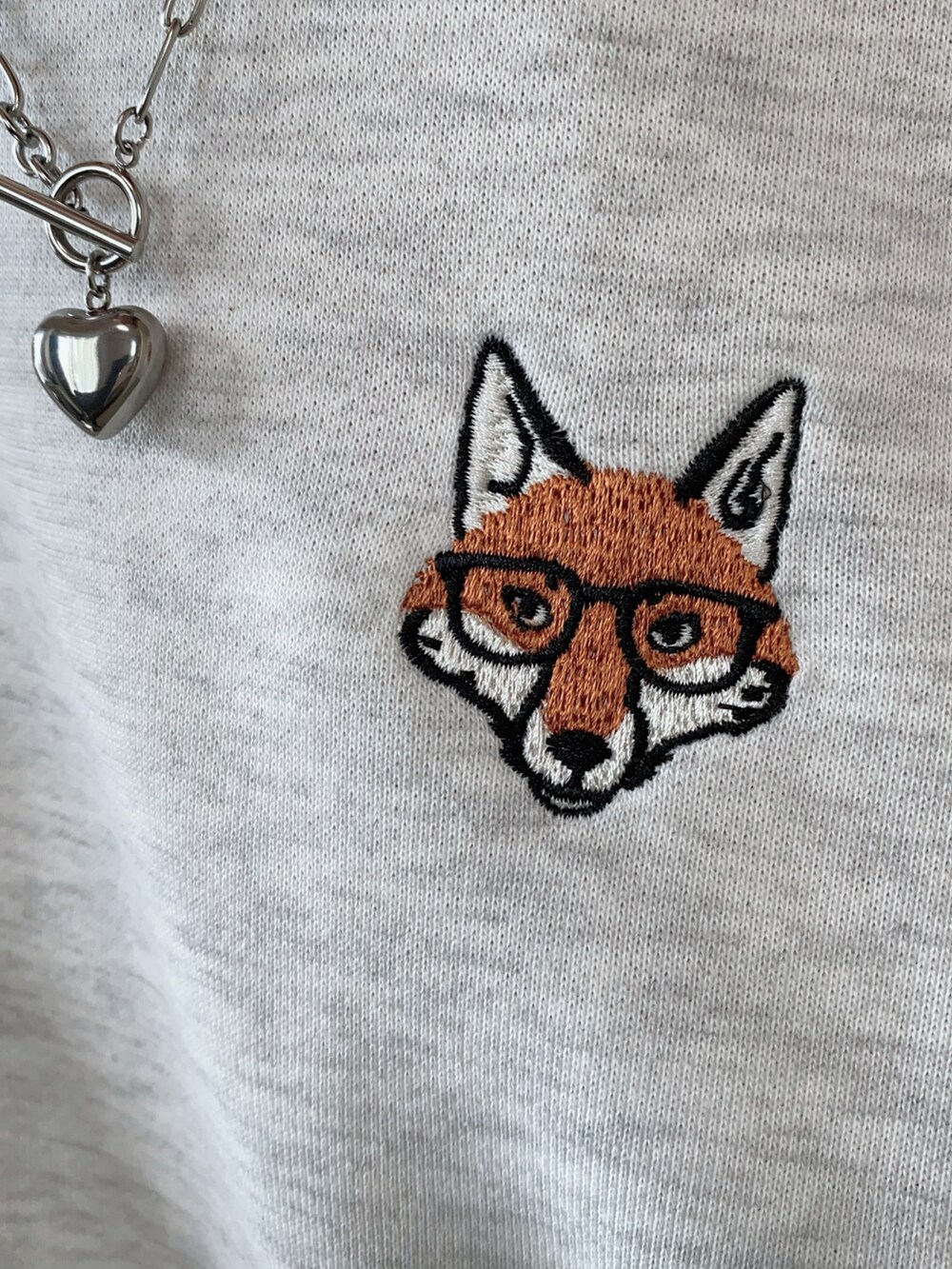 グレー系のスカート、ベージュ系のスウェットを着用したレディースの秋コーディネートの4枚目の写真