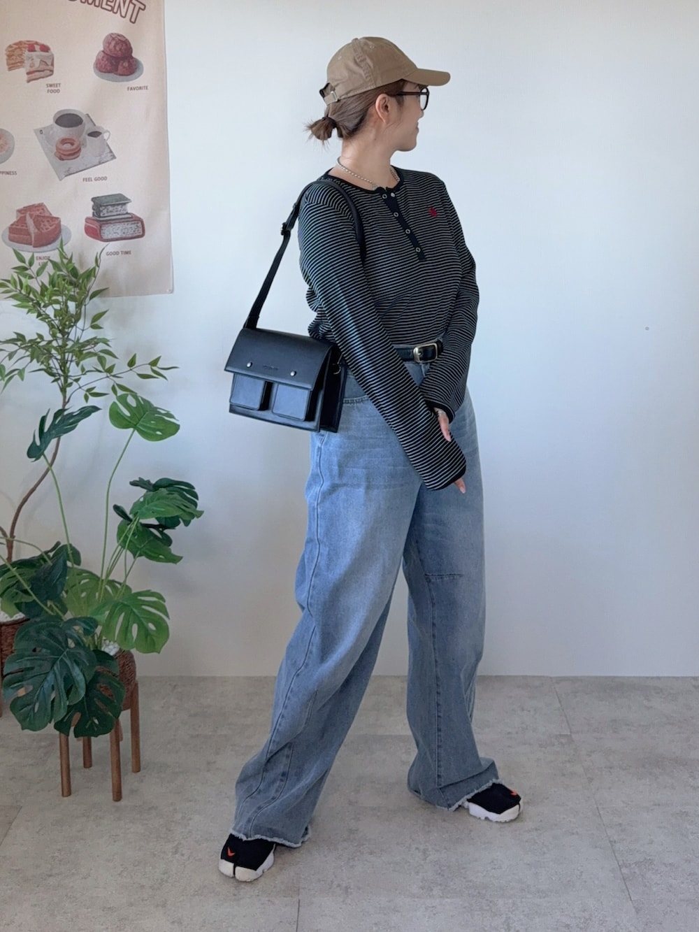 ブラック系のTシャツ/カットソー、ブラック系のショルダーバッグ、ブラック系のスニーカーを着用したレディースの冬コーディネートの2枚目の写真