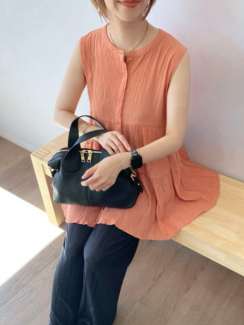 オレンジ系のシャツ/ブラウス、ブラック系のバッグ、ブラック系のその他パンツを着用したレディースの夏コーディネートの3枚目の写真