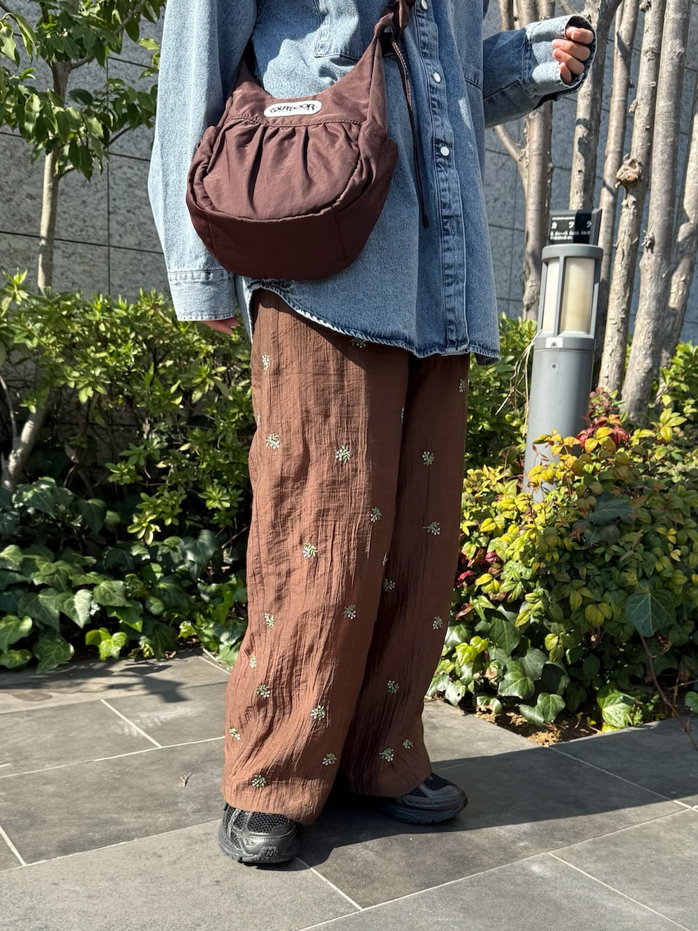 ブルー系のシャツ/ブラウス、ブラック系のスニーカー、ブラウン系のその他パンツを着用したレディースの春コーディネートの3枚目の写真