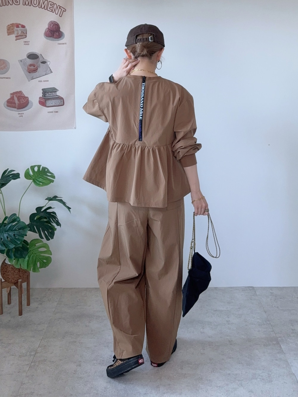 イエロー系のその他パンツ、ブラウン系のシューズ、ブラウン系のキャップを着用したレディースの夏コーディネートの2枚目の写真