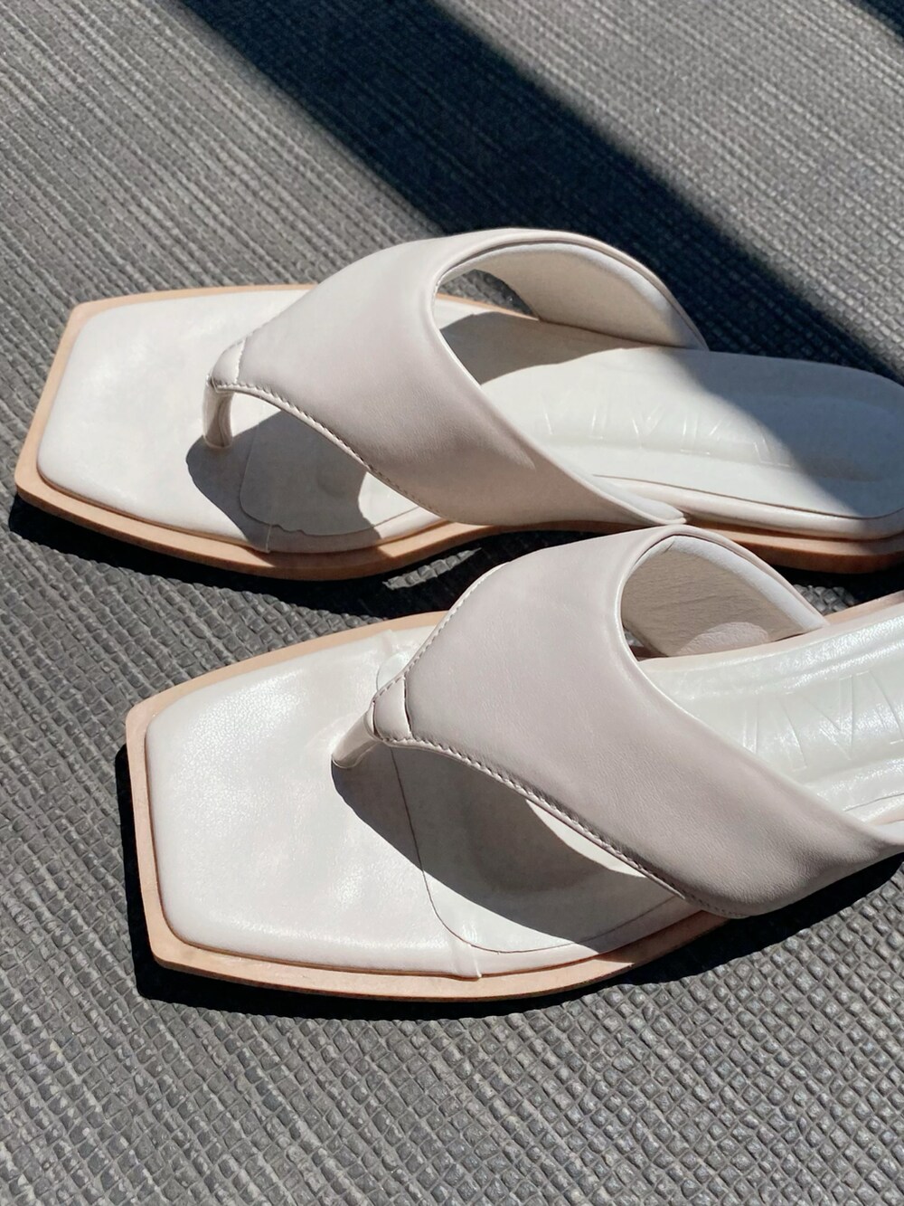 ホワイト系のサンダル、オレンジ系のバッグ、ベージュ系のワンピースを着用したレディースの夏コーディネートの4枚目の写真