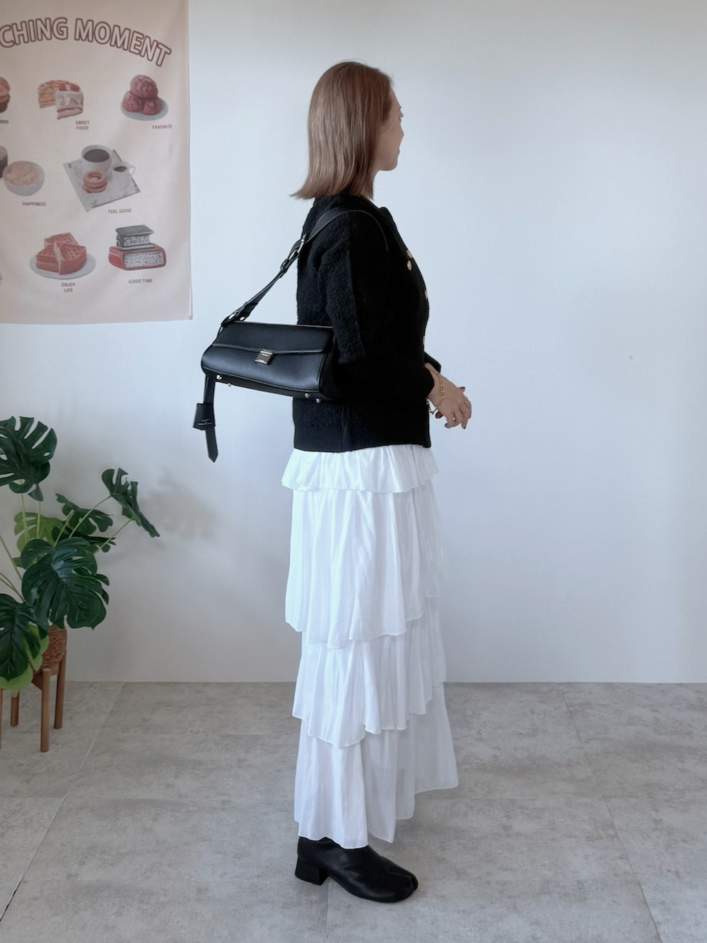 ブラック系のブーツ、ホワイト系のスカート、ブラック系のカーディガン/ボレロを着用したレディースの秋コーディネートの4枚目の写真
