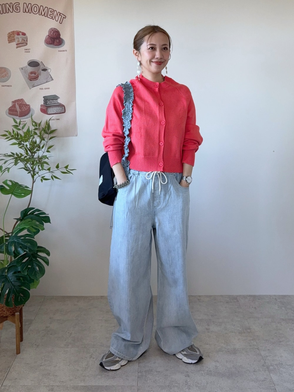 ブルー系のデニムパンツ、ブラック系のショルダーバッグ、グレー系のスニーカーを着用したレディースの春コーディネートの2枚目の写真