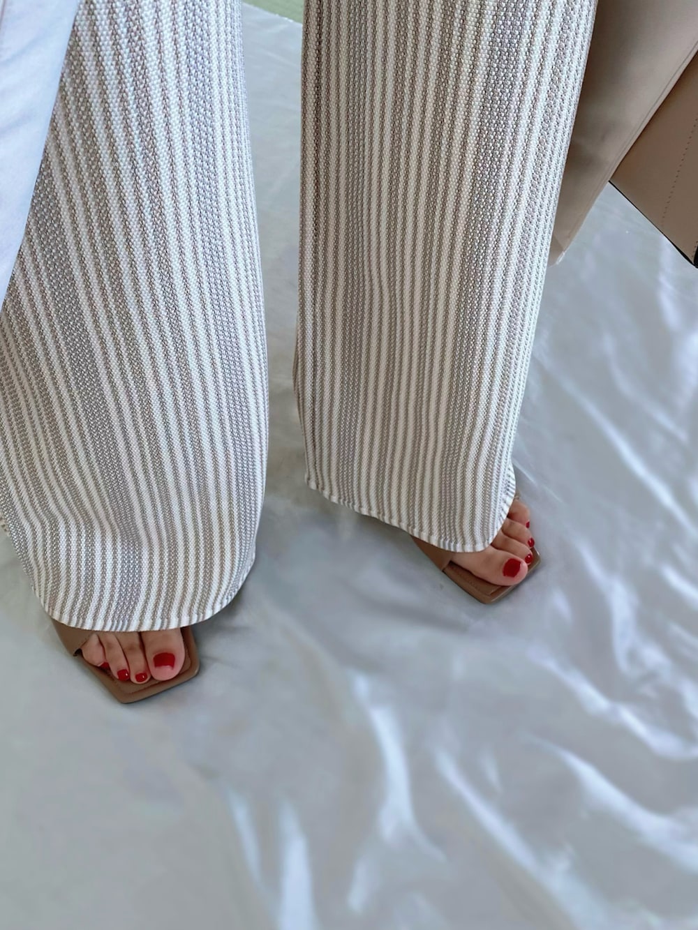 ホワイト系のその他パンツ、ホワイト系のベスト、ベージュ系のバッグを着用したレディースの夏コーディネートの4枚目の写真