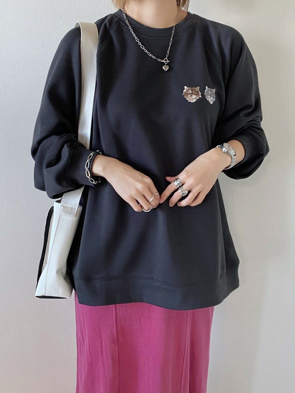 ピンク系のスカート、グレー系のスウェット、ホワイト系のショルダーバッグを着用したレディースの冬コーディネートの3枚目の写真