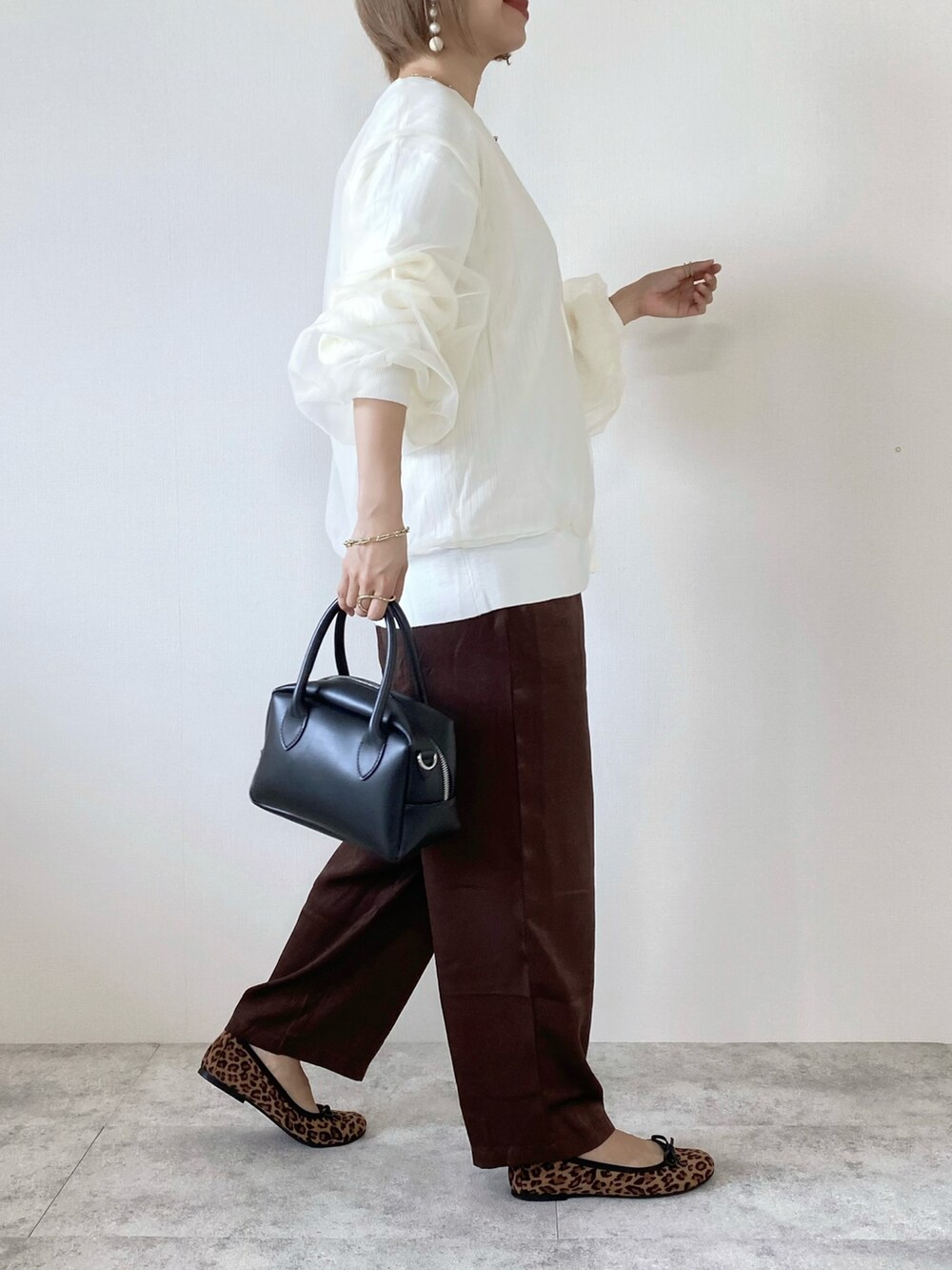 ホワイト系のカーディガン/ボレロ、ブラウン系のその他パンツ、ブラウン系のバレエシューズを着用したレディースの秋コーディネートの4枚目の写真
