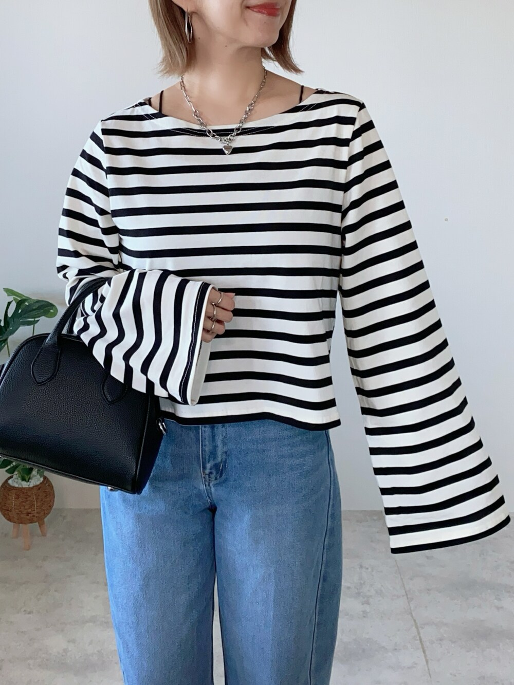 ブラック系のボストンバッグ、レッド系のバレエシューズ、ブラック系のTシャツ/カットソーを着用したレディースの夏コーディネートの3枚目の写真