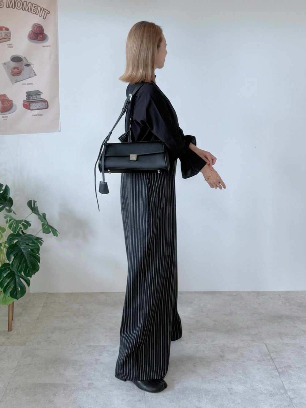 ブラック系のブーツ、ブラック系のシャツ/ブラウス、ブラック系のショルダーバッグを着用したレディースの秋コーディネートの2枚目の写真