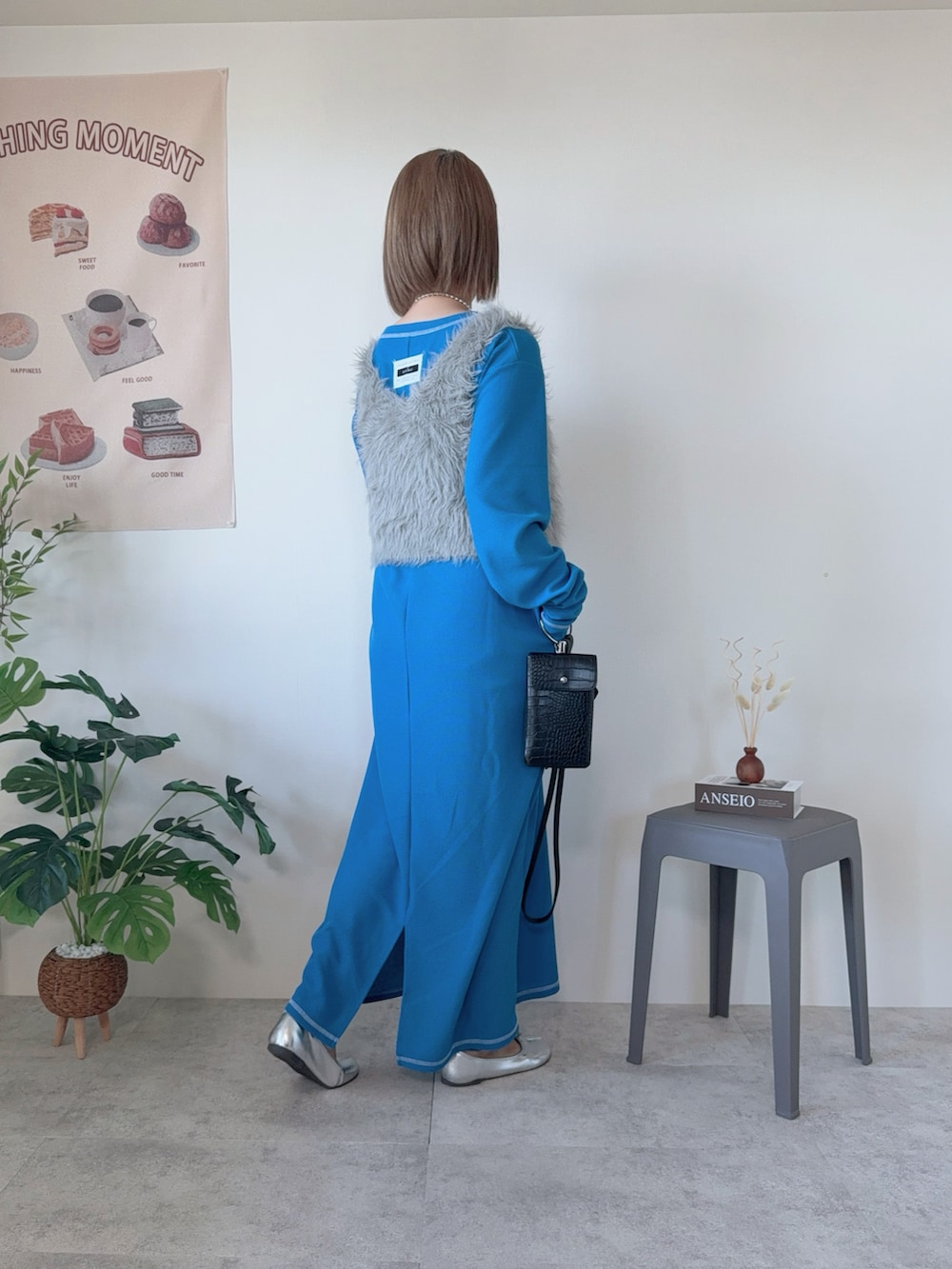 シルバー系のバレエシューズ、ブルー系のワンピース、ベージュ系のベストを着用したレディースの冬コーディネートの2枚目の写真