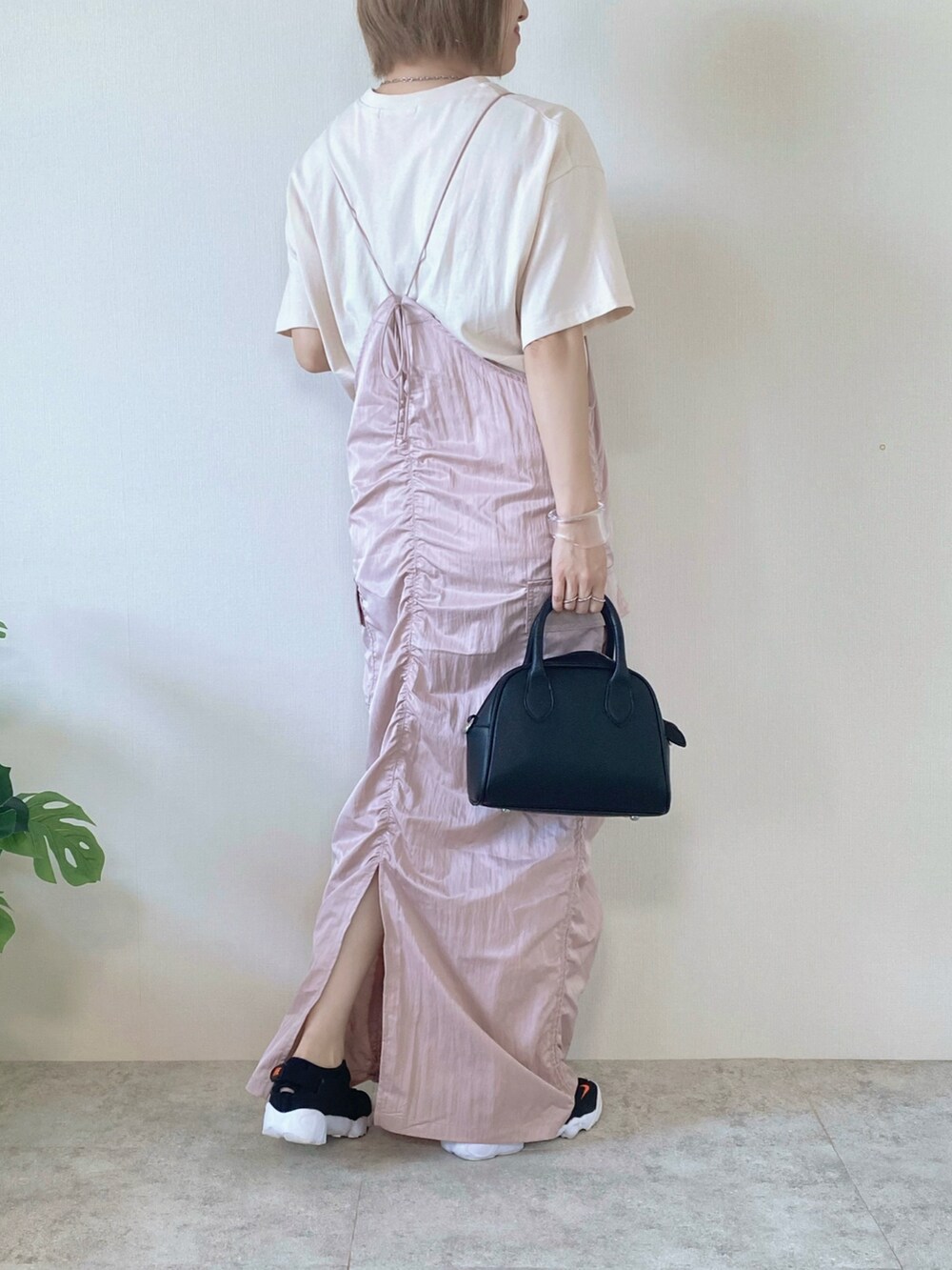 ブラック系のボストンバッグ、ピンク系のワンピース、ベージュ系のTシャツ/カットソーを着用したレディースの夏コーディネートの2枚目の写真