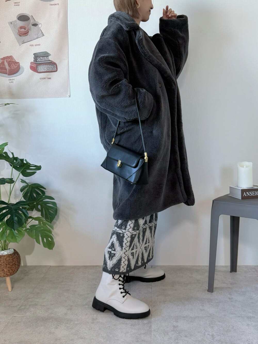 グレー系のピーコート、ブラック系のハンドバッグ、グレー系のスカートを着用したレディースの冬コーディネートの3枚目の写真