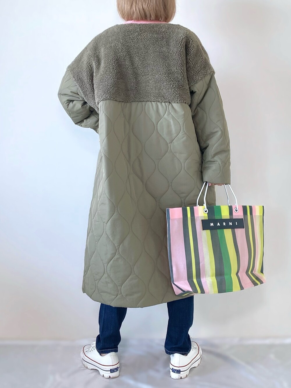 グリーン系のダウンジャケット/コート、ピンク系のニット/セーター、グリーン系のトートバッグを着用したレディースの秋コーディネートの3枚目の写真