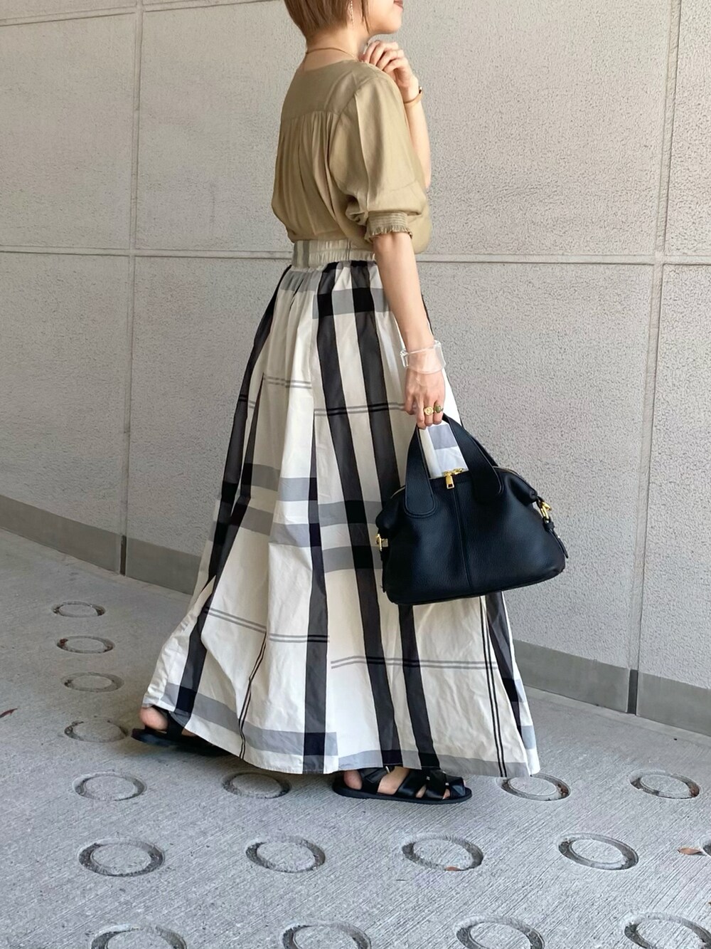 イエロー系のシャツ/ブラウス、ホワイト系のスカート、ブラック系のバッグを着用したレディースの夏コーディネートの3枚目の写真