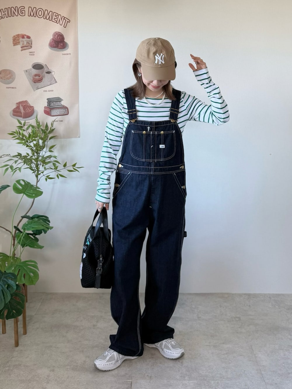 ホワイト系のスニーカー、ブラック系のボストンバッグ、グリーン系のTシャツ/カットソーを着用したレディースの冬コーディネートの2枚目の写真