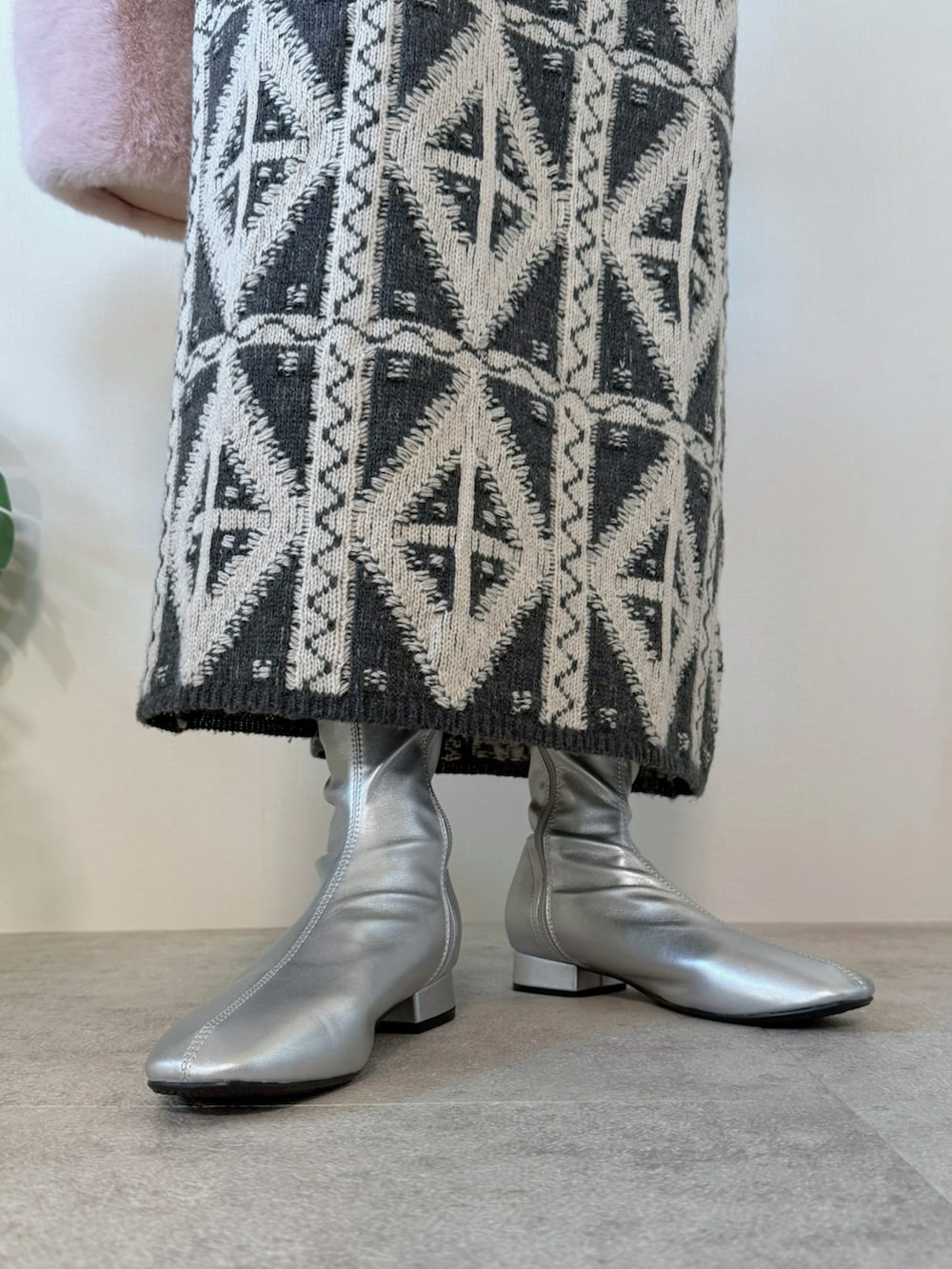 グレー系のスカート、グレー系のスウェット、シルバー系のブーツを着用したレディースの冬コーディネートの4枚目の写真
