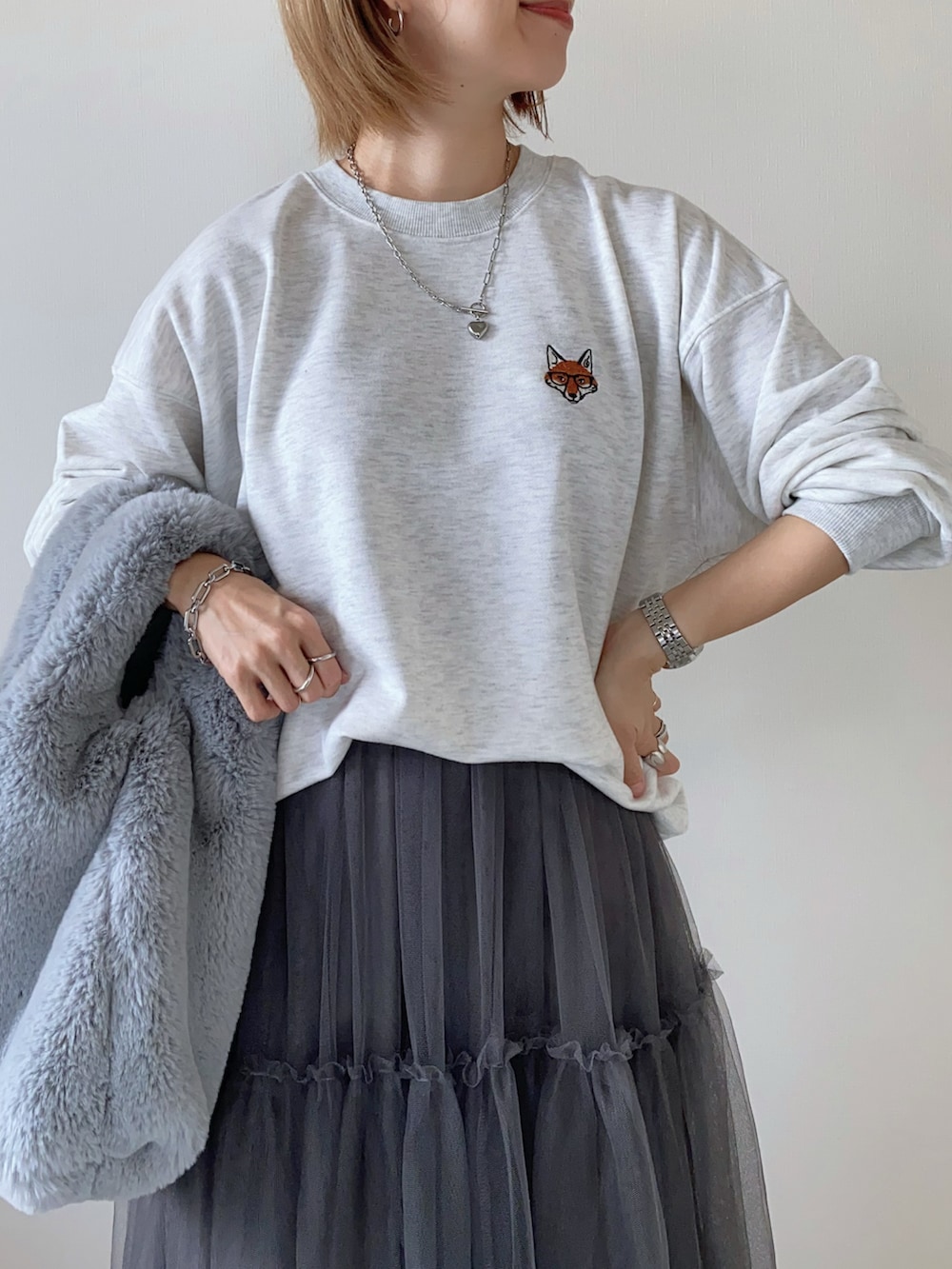 グレー系のスカート、ベージュ系のスウェットを着用したレディースの秋コーディネートの3枚目の写真