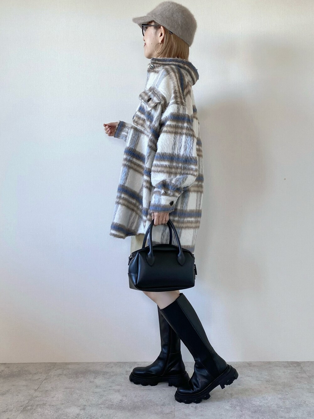 ホワイト系のブルゾン、ブラック系のニット/セーター、ブラック系のバッグを着用したレディースの秋コーディネートの4枚目の写真