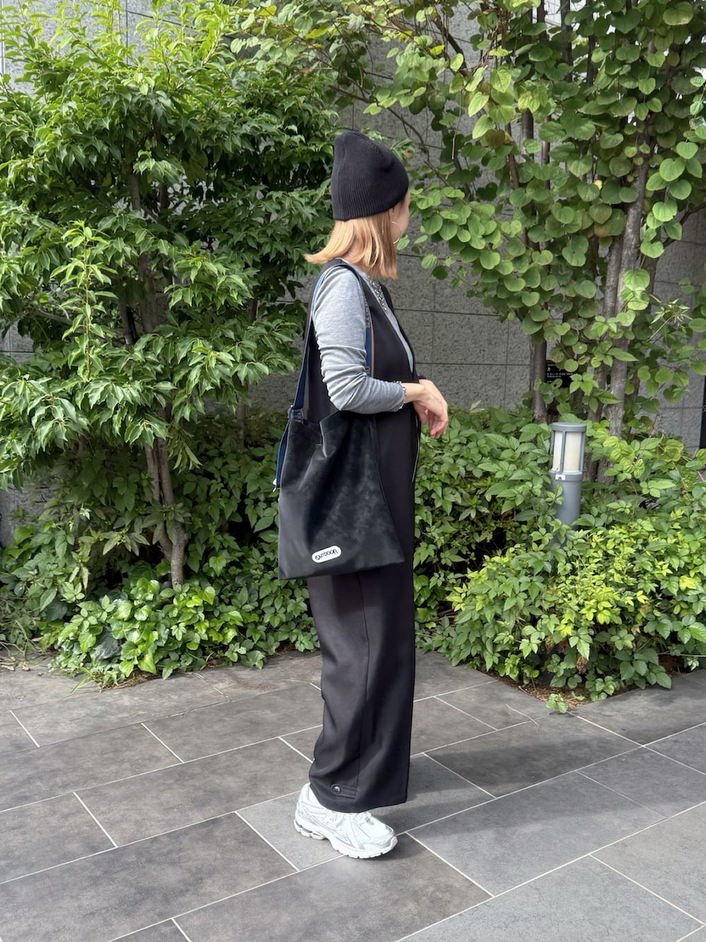 シルバー系のスニーカー、ブラック系のトートバッグ、ブラック系のつなぎ/オールインワンを着用したレディースの秋コーディネートの5枚目の写真