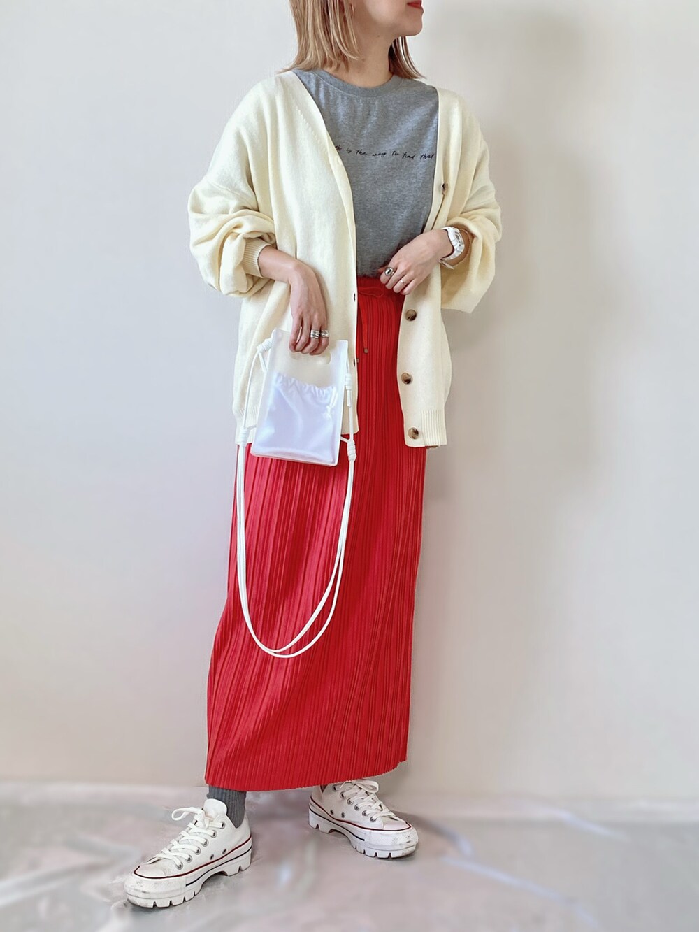 ホワイト系のカーディガン/ボレロ、ピンク系のスカート、ホワイト系のスニーカーを着用したレディースの春コーディネートの3枚目の写真