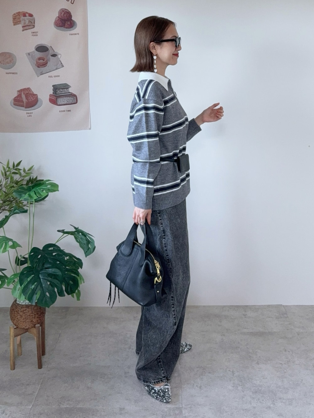 グレー系のニット/セーター、グレー系のデニムパンツ、ブラック系のベルトを着用したレディースの秋コーディネートの2枚目の写真