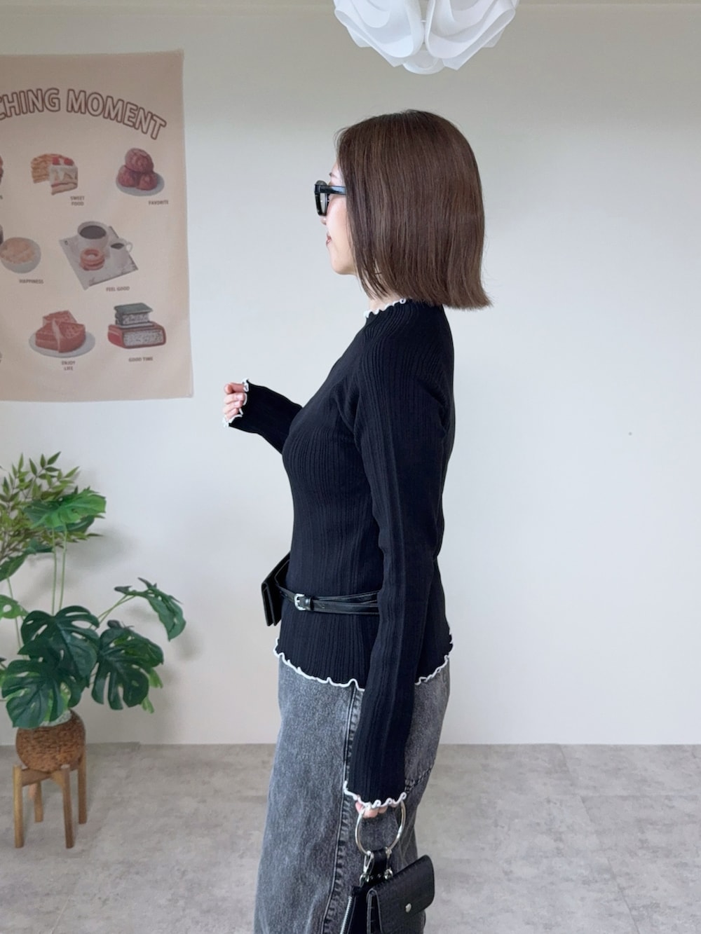 ブラック系のニット/セーター、グレー系のデニムパンツ、ブラック系のベルトを着用したレディースの秋コーディネートの4枚目の写真