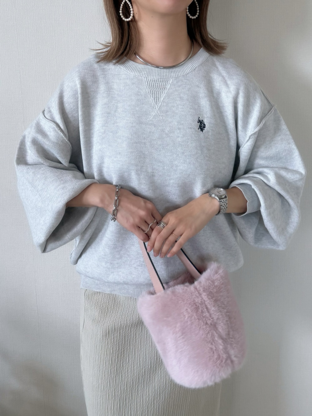 ベージュ系のニット/セーター、ベージュ系のスカート、グレー系のスニーカーを着用したレディースの秋コーディネートの2枚目の写真