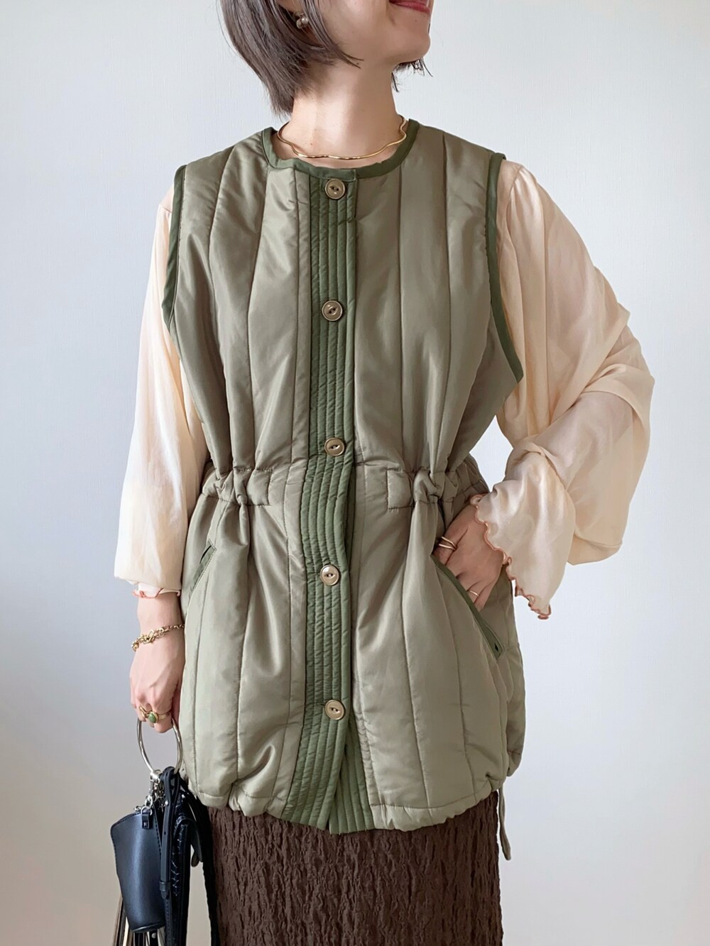 ベージュ系のTシャツ/カットソー、ブラウン系のスカート、ブラウン系のバレエシューズを着用したレディースの秋コーディネートの4枚目の写真