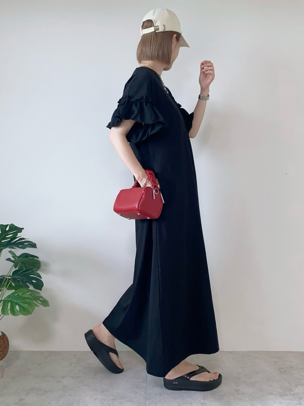 ブラック系のワンピース、レッド系のボストンバッグ、ブラック系のサンダルを着用したレディースの夏コーディネートの4枚目の写真