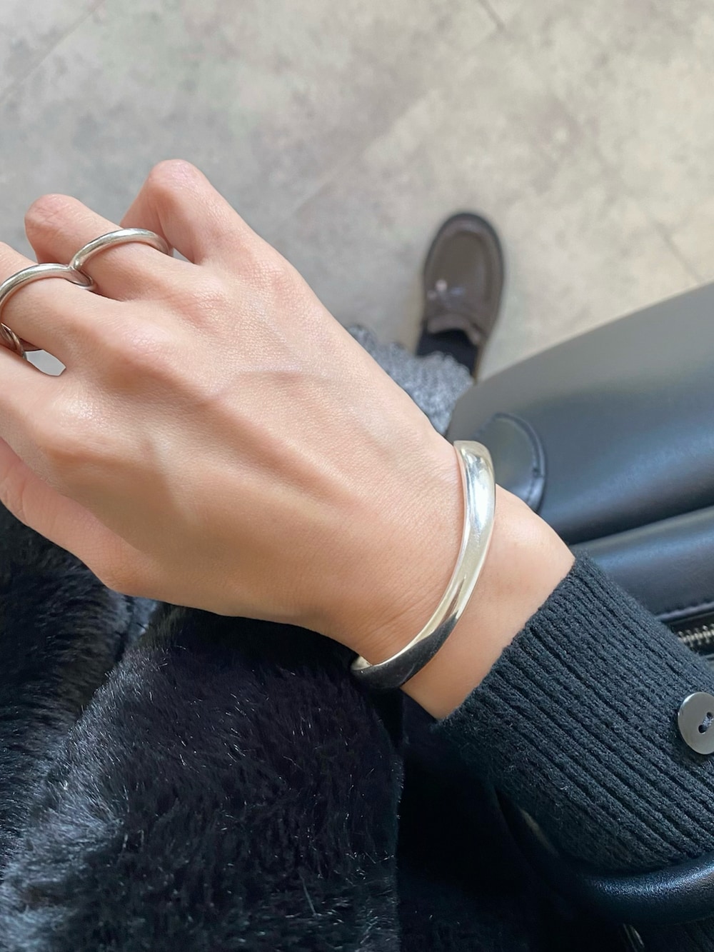 ブラック系のその他アウター、ブラック系のニット/セーター、ブラック系のバッグを着用したレディースの秋コーディネートの5枚目の写真