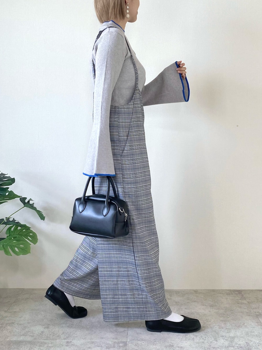 グレー系のニット/セーター、その他のサロペット/オーバーオール、ブラック系のバッグを着用したレディースの冬コーディネートの2枚目の写真