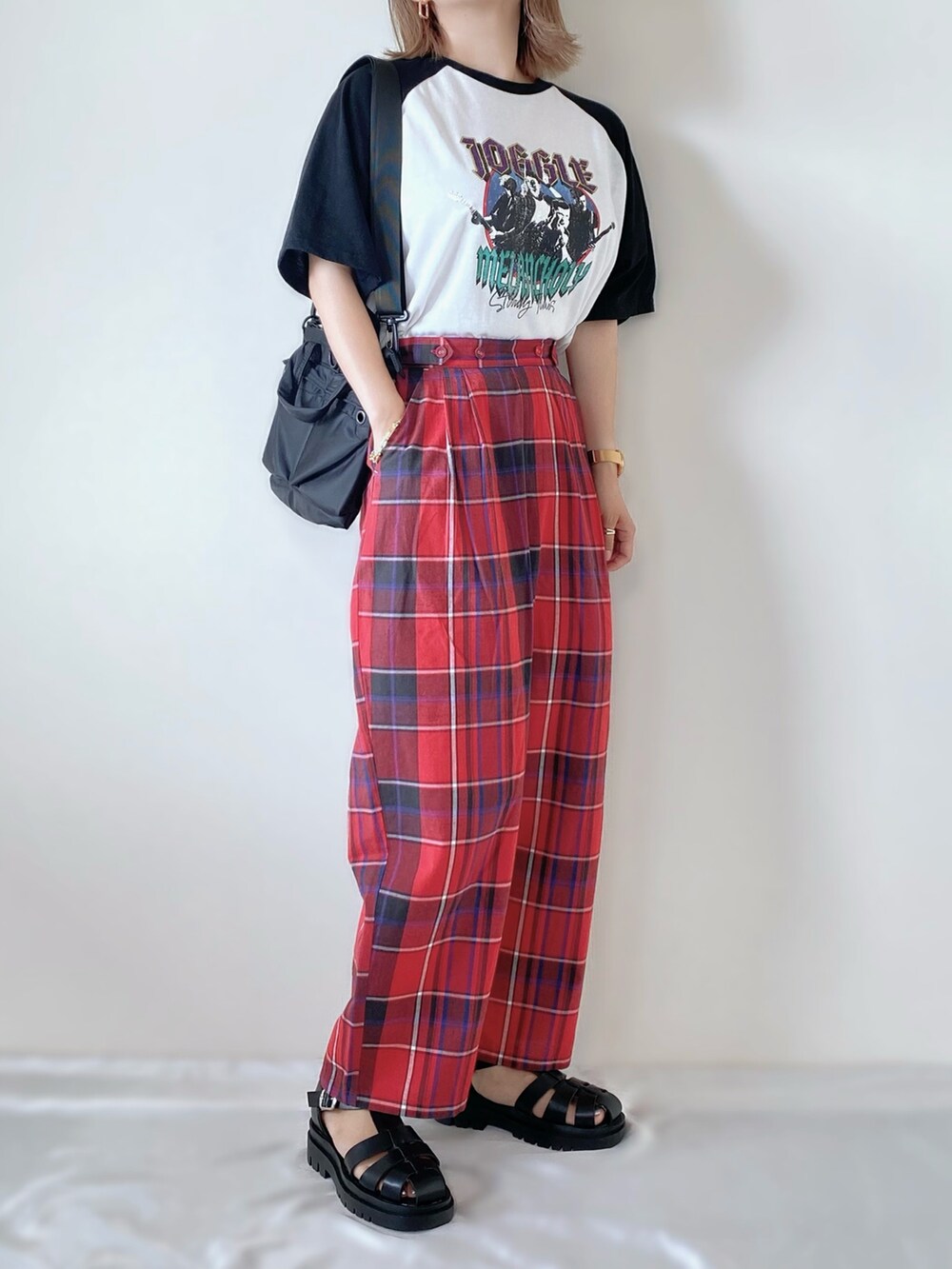 レッド系のパンツ、ブラック系のTシャツ/カットソー、ブラック系のサンダルを着用したレディースの夏コーディネートの2枚目の写真