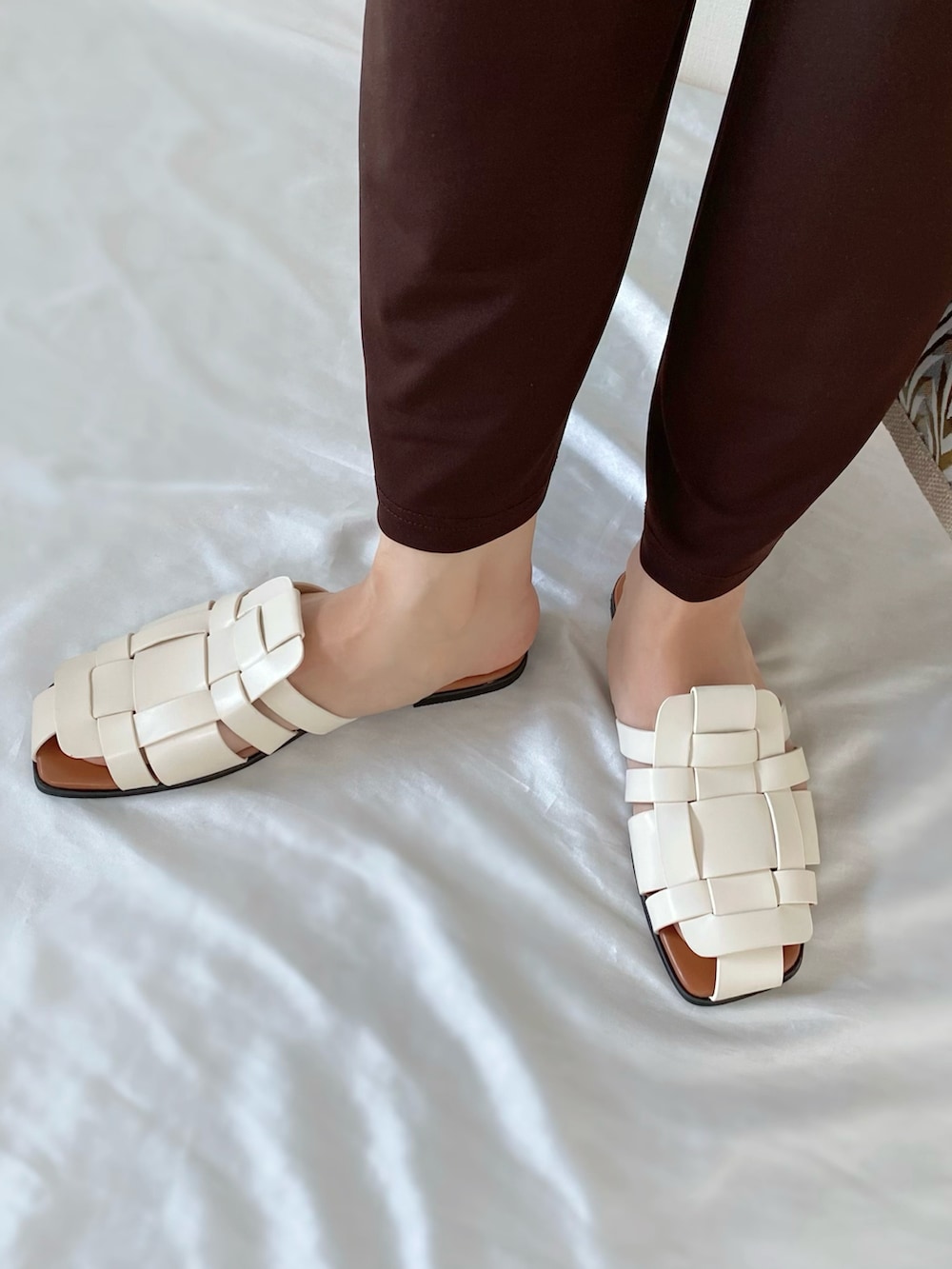 イエロー系のかごバッグ、ブラウン系のその他トップス、ホワイト系のサンダルを着用したレディースの夏コーディネートの3枚目の写真