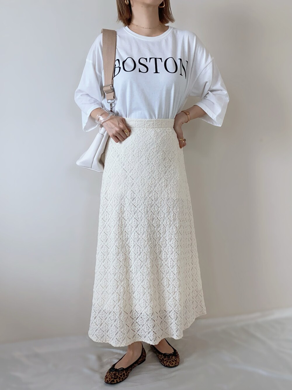 ホワイト系のTシャツ/カットソー、オレンジ系のカーディガン/ボレロ、ホワイト系のスカートを着用したレディースの春コーディネートの3枚目の写真