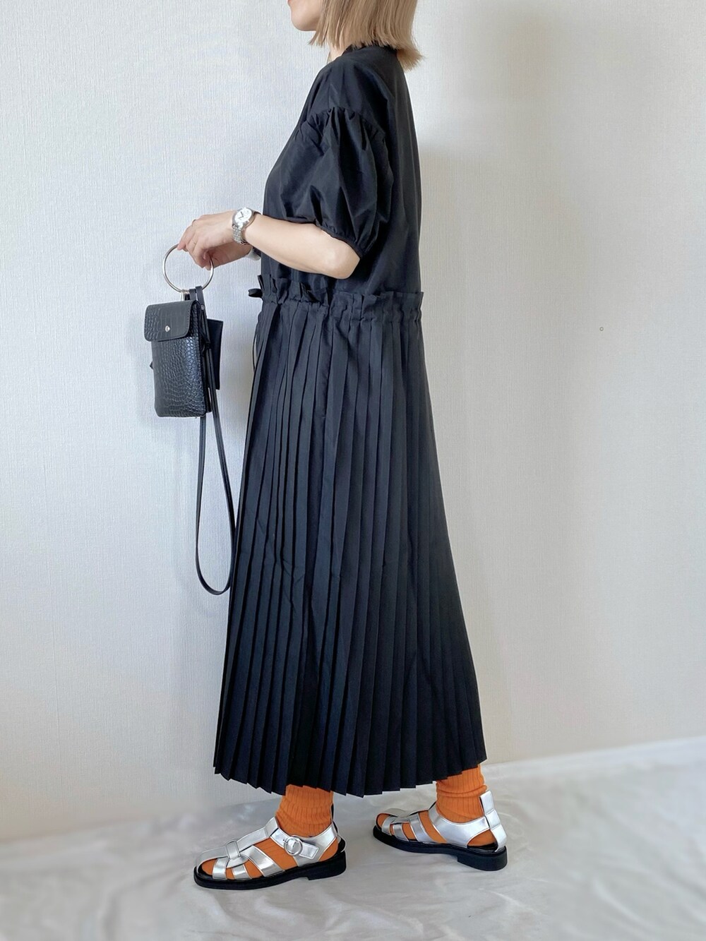 ブラック系のワンピース、ブラック系のショルダーバッグ、シルバー系のサンダルを着用したレディースの夏コーディネートの2枚目の写真
