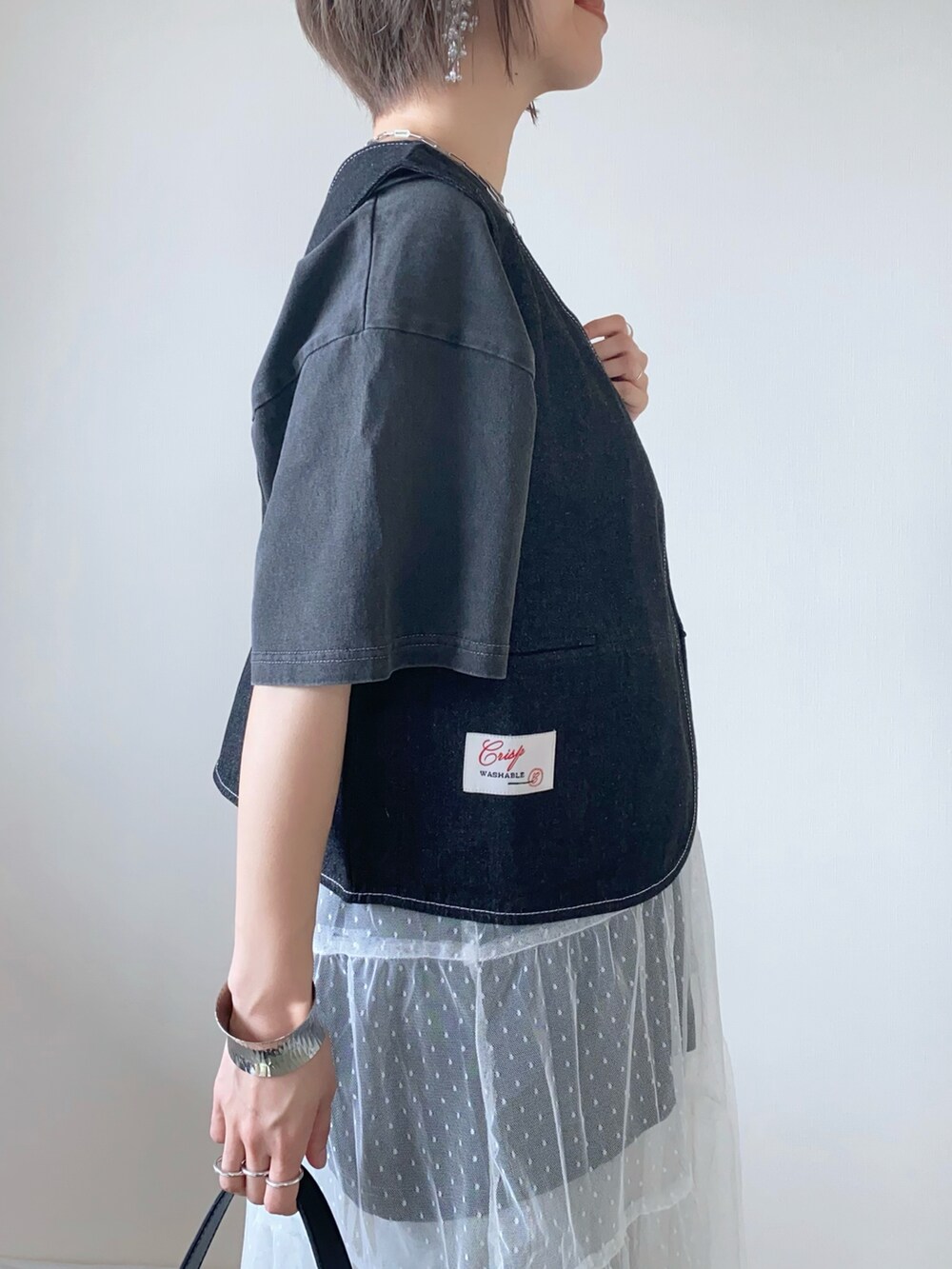 ブラック系のバッグ、ブラック系のサンダル、グレー系のデニムパンツを着用したレディースの夏コーディネートの5枚目の写真