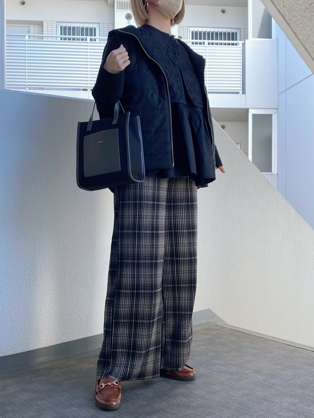 ブラック系のシャツ/ブラウス、ブラック系のブルゾン、ブラック系のトートバッグを着用したレディースの冬コーディネートの2枚目の写真