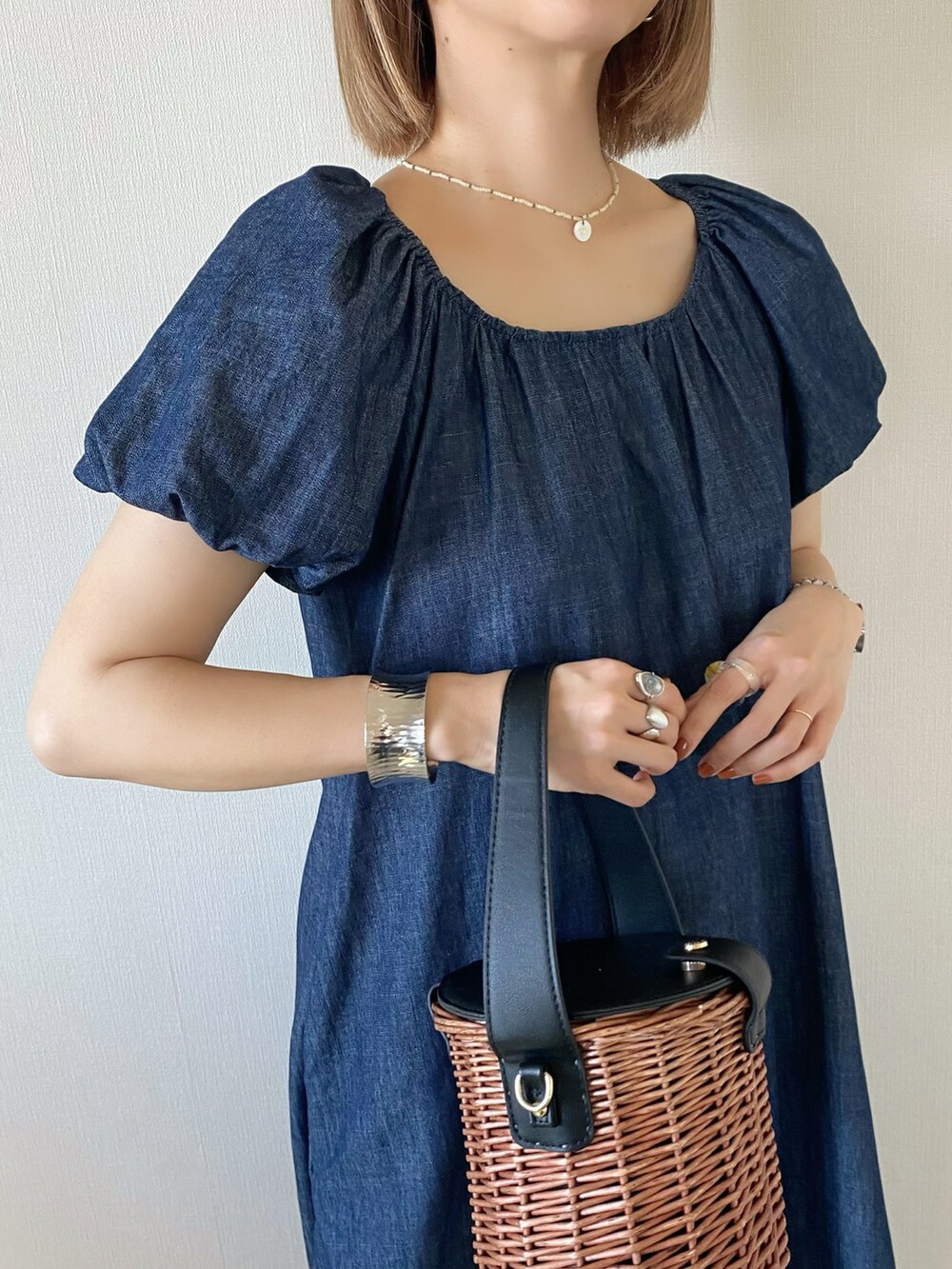 ブラック系のバッグ、ブルー系のワンピース、ブラック系のサンダルを着用したレディースの春コーディネートの4枚目の写真