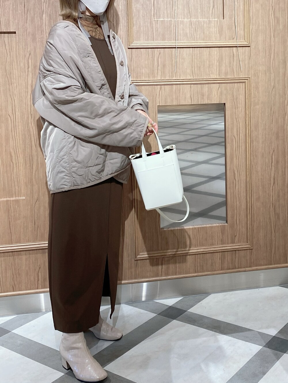 ベージュ系のノーカラージャケット、ブラウン系のジャンパースカート、ブラウン系のTシャツ/カットソーを着用したレディースの秋コーディネートの2枚目の写真