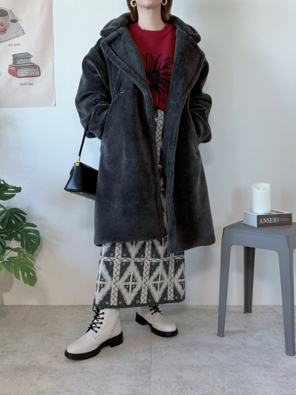 グレー系のピーコート、ブラック系のハンドバッグ、グレー系のスカートを着用したレディースの冬コーディネートの2枚目の写真