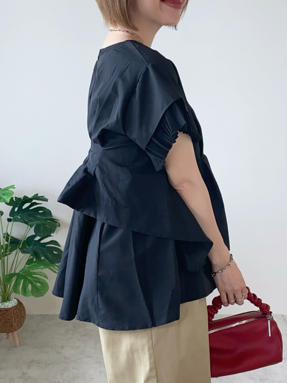 ブラック系のシャツ/ブラウス、ベージュ系のチノパンツ、レッド系のボストンバッグを着用したレディースの夏コーディネートの3枚目の写真