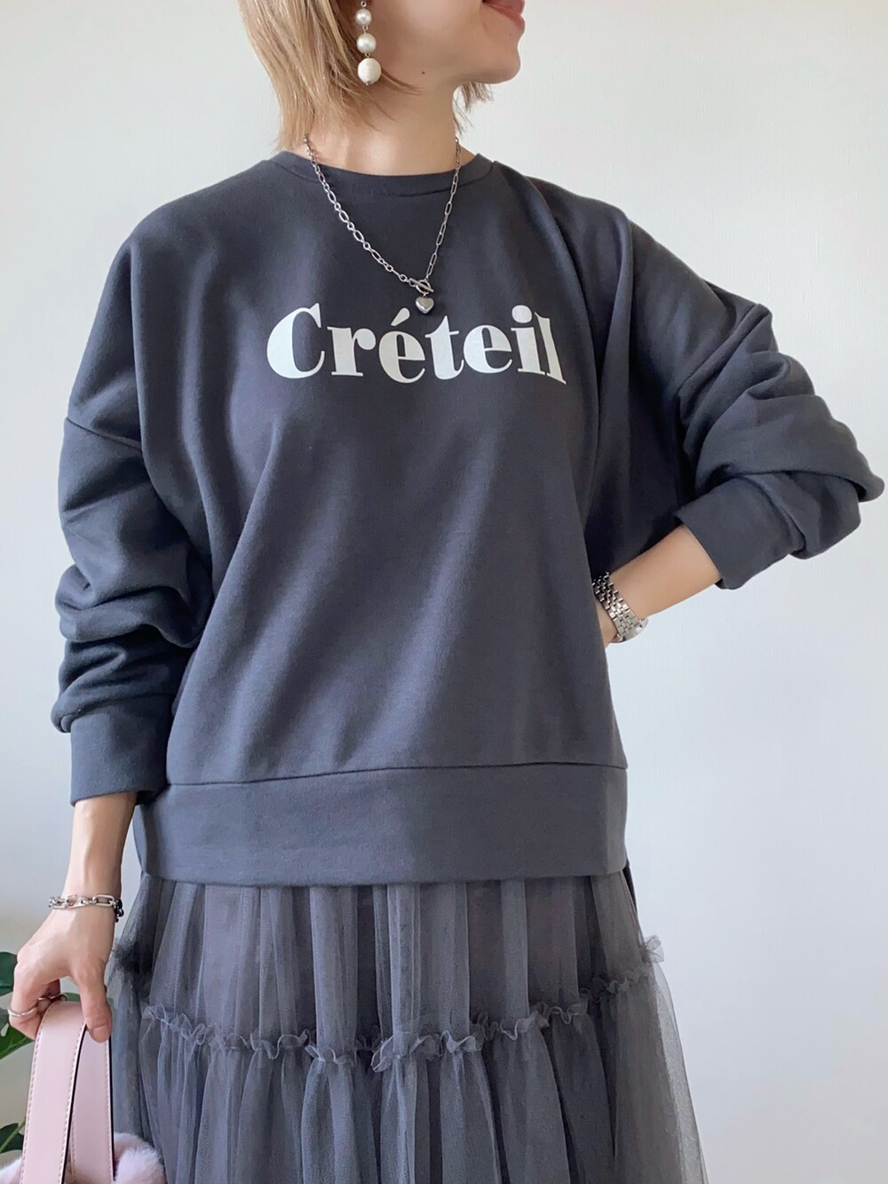 ピンク系のバッグ、グレー系のスカート、グレー系のスウェットを着用したレディースの秋コーディネートの3枚目の写真