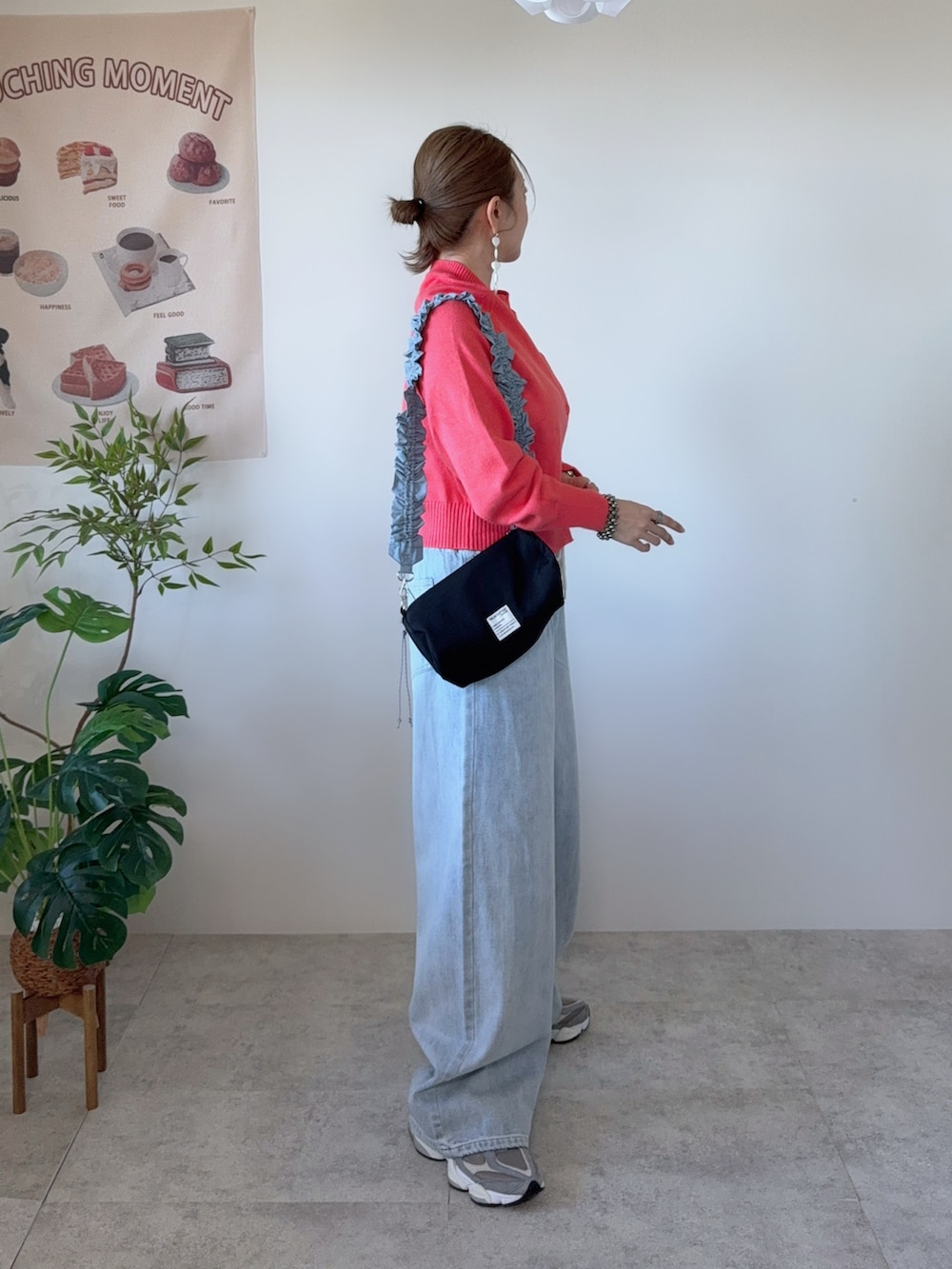 ブルー系のデニムパンツ、ブラック系のショルダーバッグ、グレー系のスニーカーを着用したレディースの春コーディネートの3枚目の写真