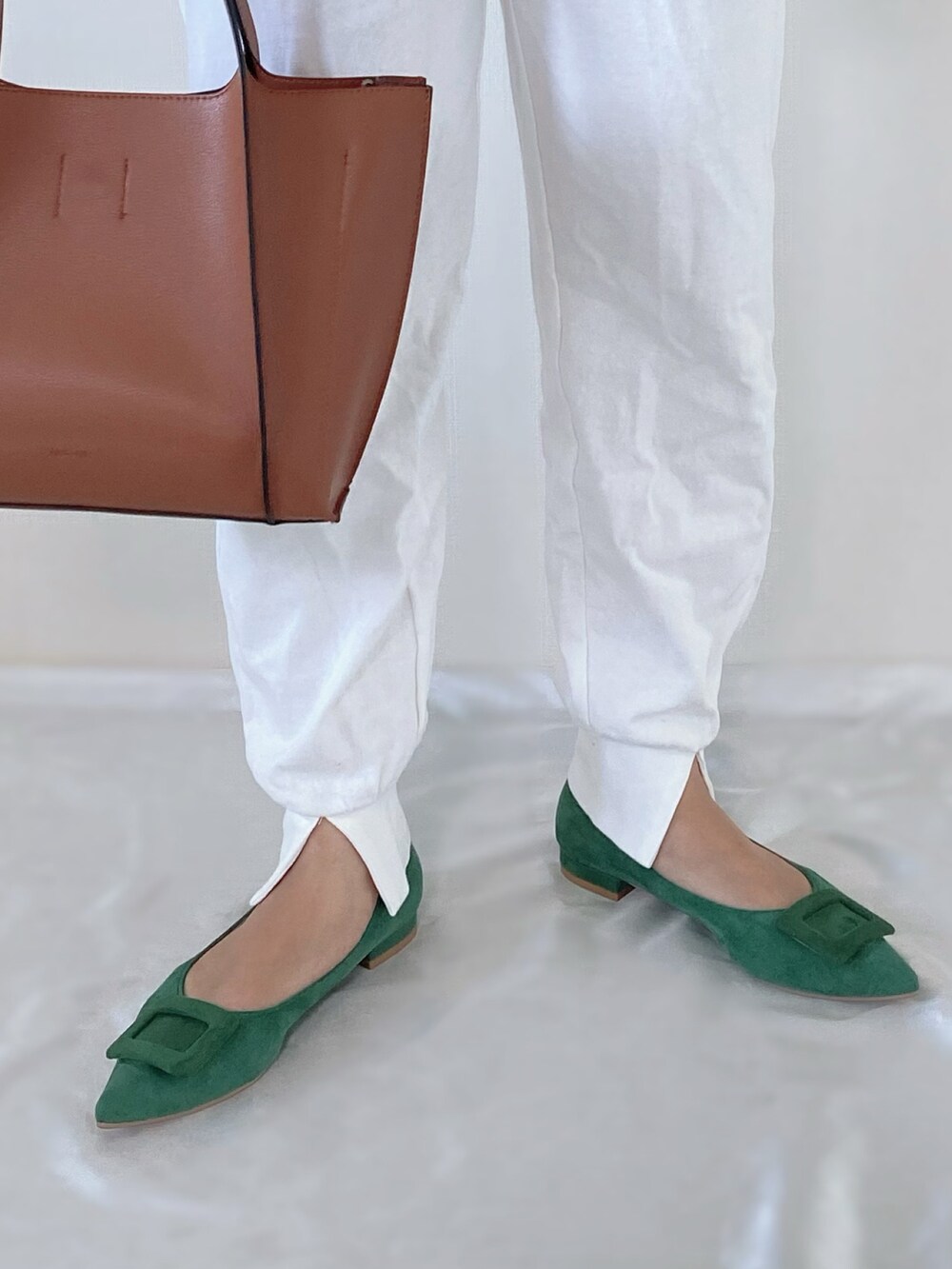 グリーン系のパンプス、ホワイト系のその他パンツ、ブラウン系のバッグを着用したレディースの夏コーディネートの2枚目の写真