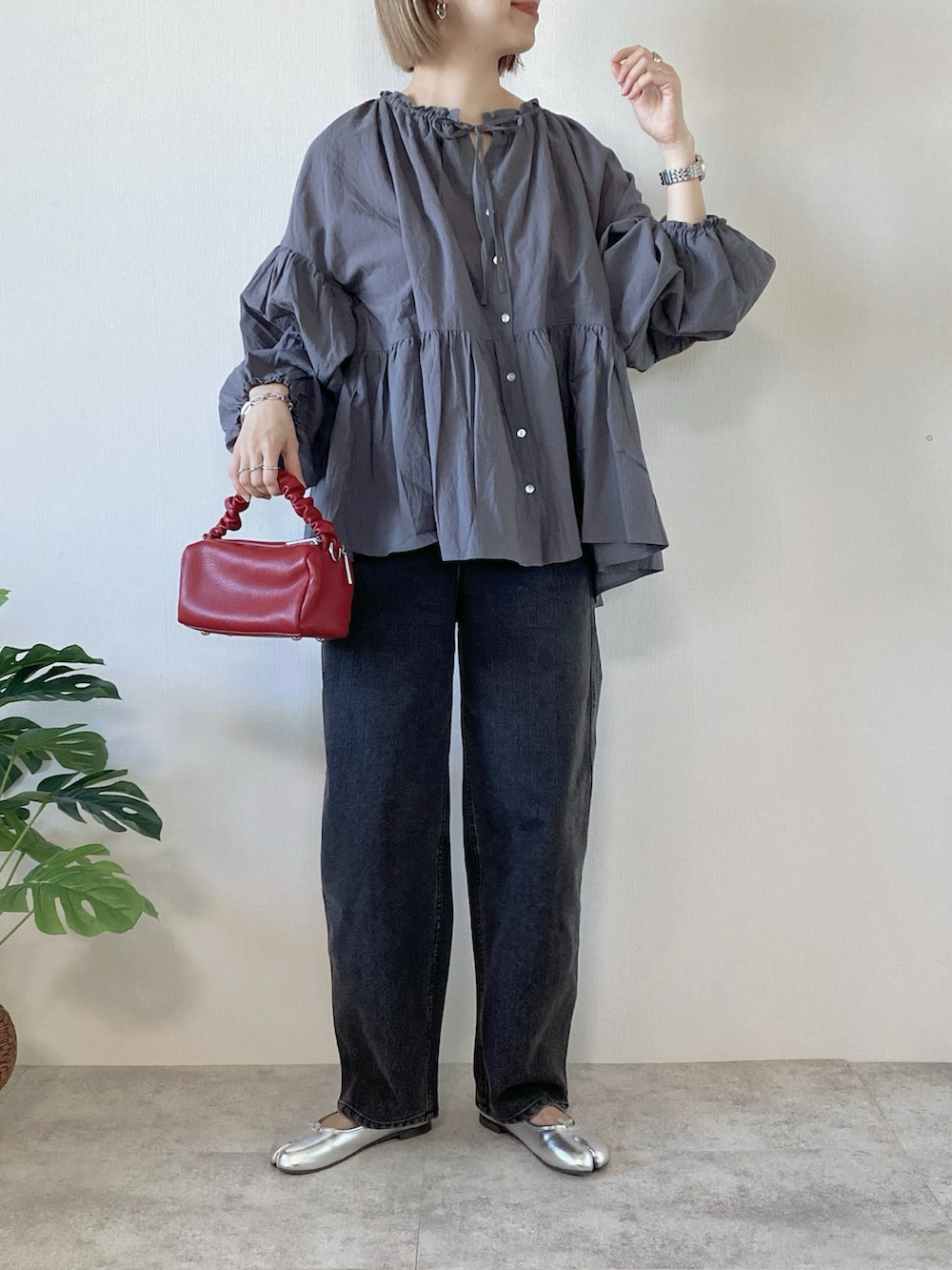 グレー系のシャツ/ブラウス、ブラック系のデニムパンツ、レッド系のボストンバッグを着用したレディースの春コーディネートの2枚目の写真