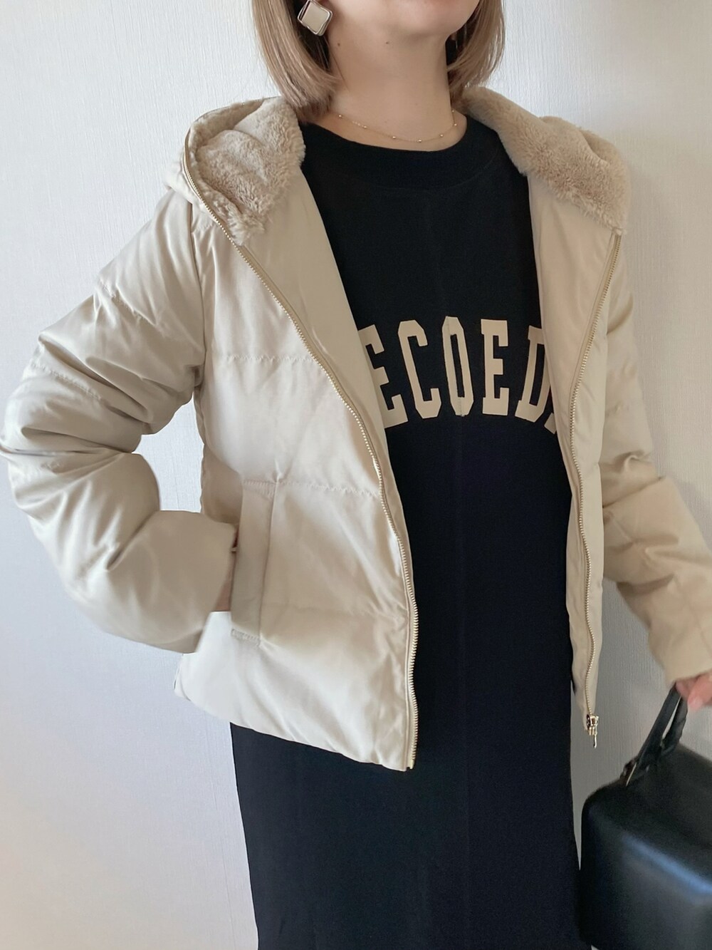 ブラック系のワンピース、ブラック系のハンドバッグ、ホワイト系のブーツを着用したレディースの秋コーディネートの4枚目の写真