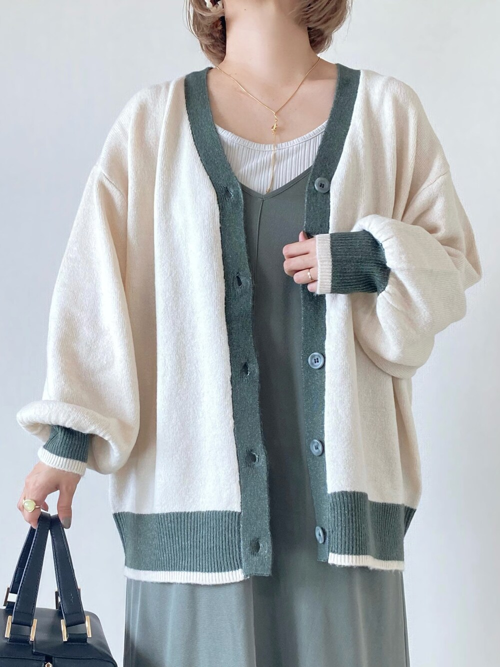 ブラック系のハンドバッグ、ブラック系のローファー、グリーン系のワンピース/ドレスを着用したレディースの秋コーディネートの4枚目の写真