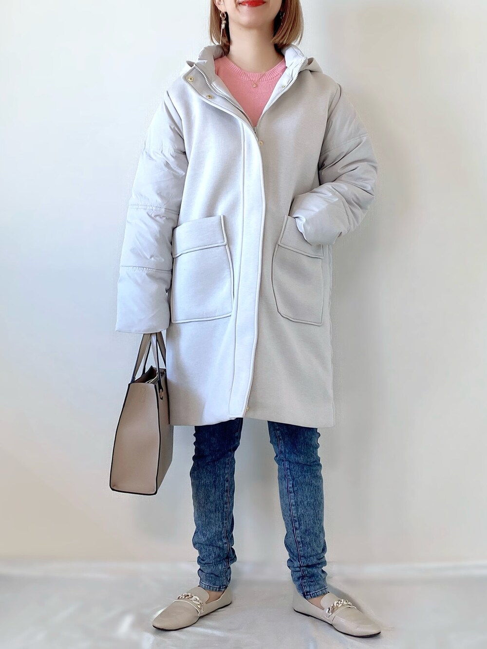 ピンク系のニット/セーター、グレー系のダウンジャケット/コート、ベージュ系のバッグを着用したレディースの冬コーディネートの4枚目の写真